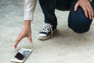 58549139-person-picking-broken-smart-phone-cracked-screen-of-the-ground-640×426-c